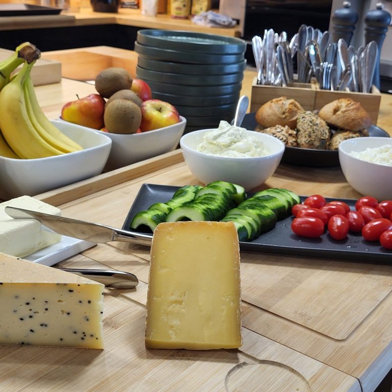 Ein Buffet mit Obst, Gemüse, Käse, Brot und Dips.